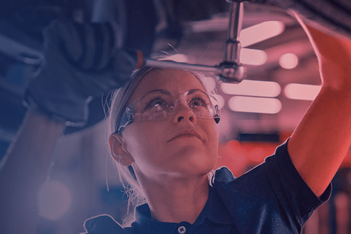 Technician working beneath a vehicle in a Group 1 workshop